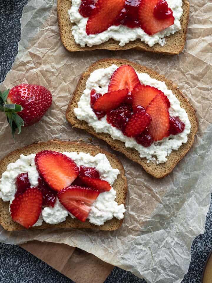 toasted bread topped with vegan tofu cottage cheese and strawberries.