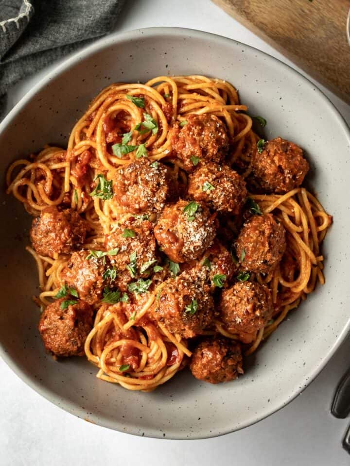 large serving bowl filled with vegan spaghetti and meatballs.