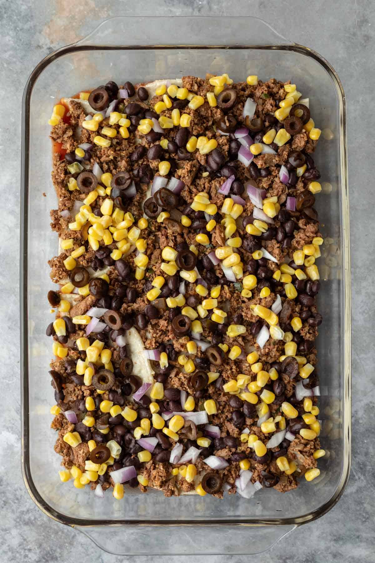 The second step is to layer in the vegan meat, beans, and veggies.
